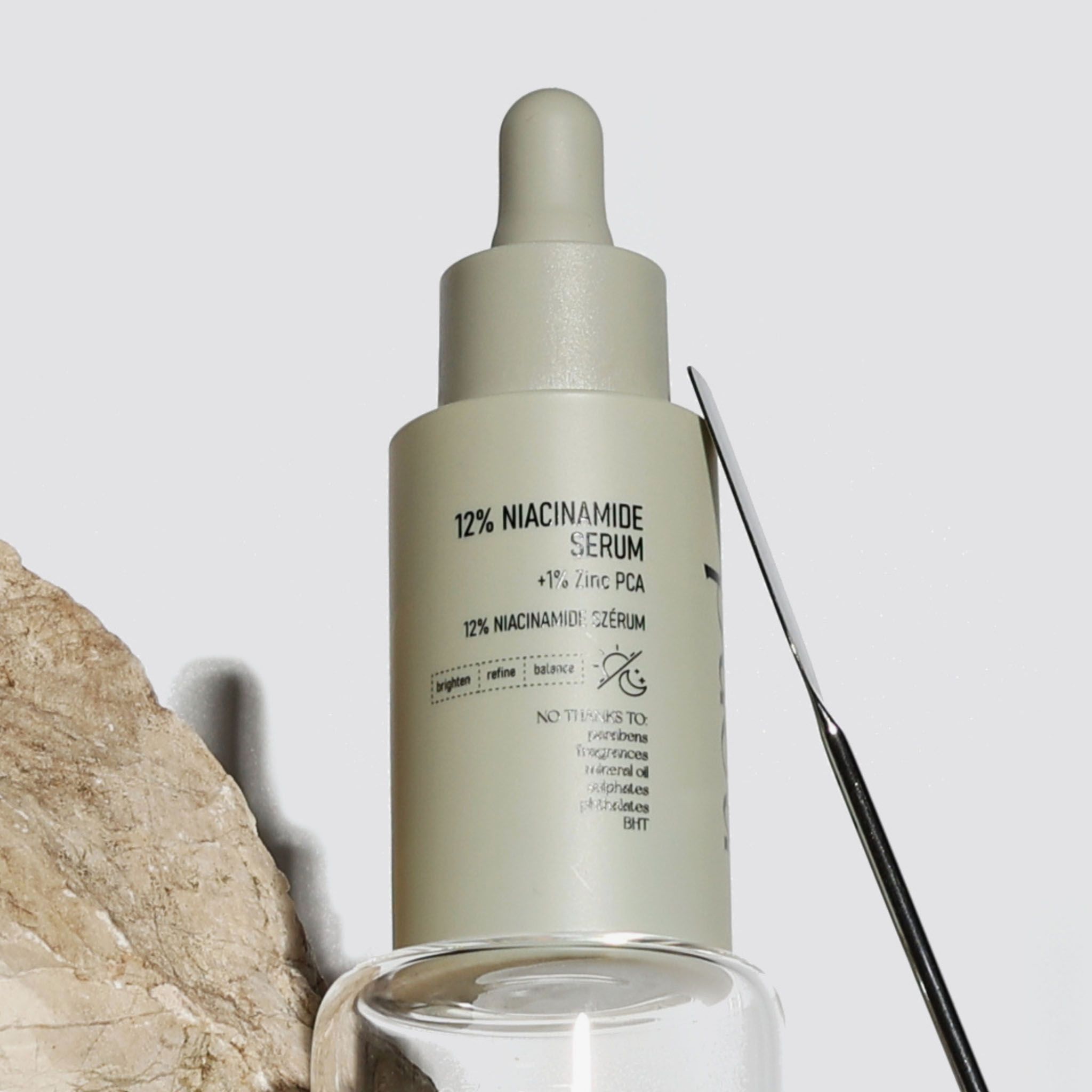 Flacone beige con contagocce, siero 12% Niacinamide, primo piano.
