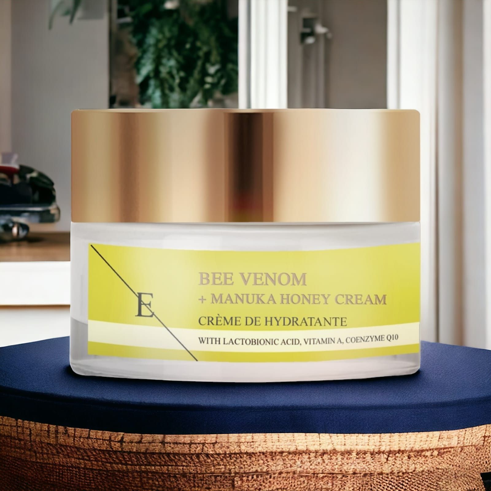 Vasetto di crema con coperchio dorato ed etichetta gialla. Testo: Veleno d'api + Crema al miele di Manuka. Con acido lattobionico, vitamina A, Q10.