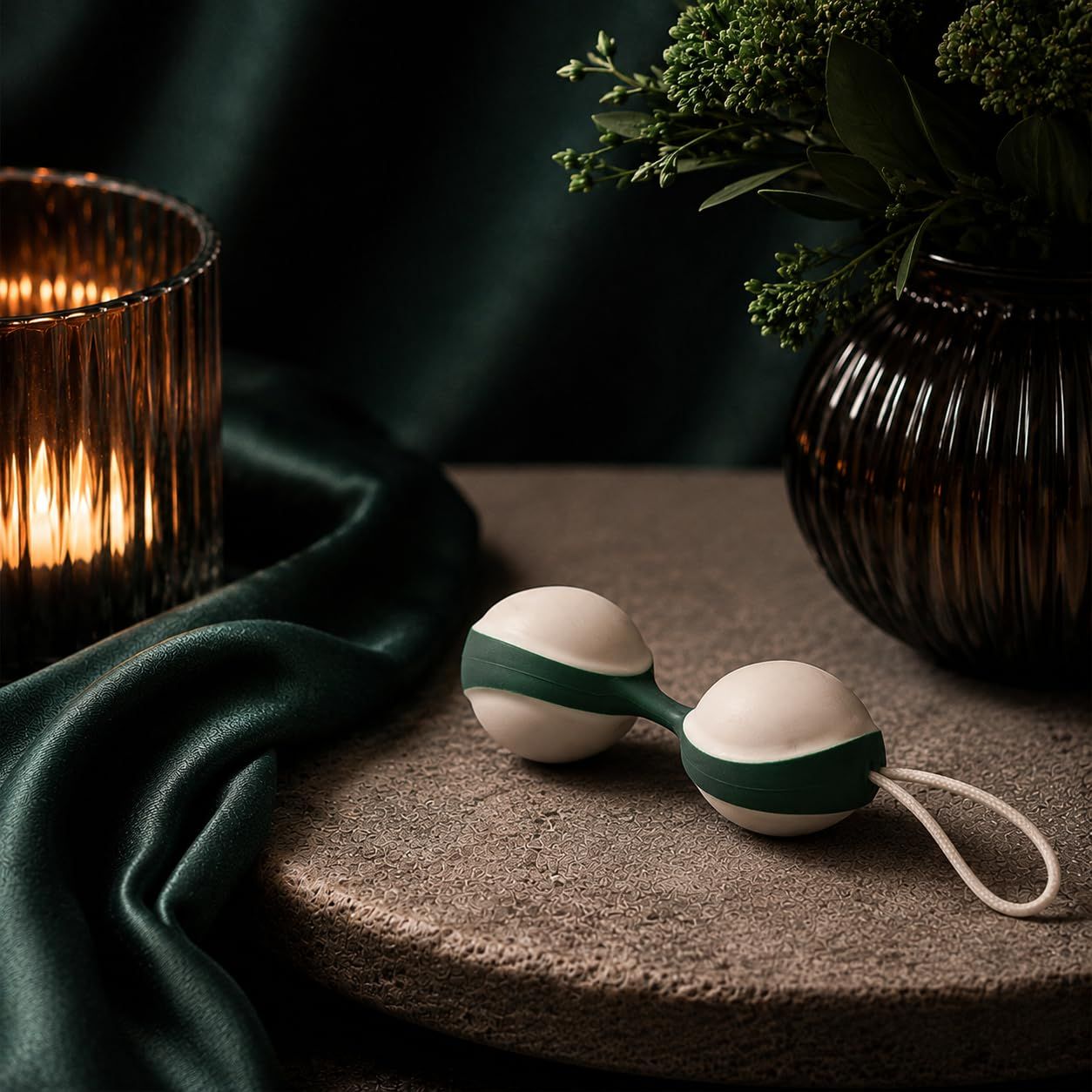 Palla duo per il pavimento pelvico con cordino, bianco e verde, su piedistallo.