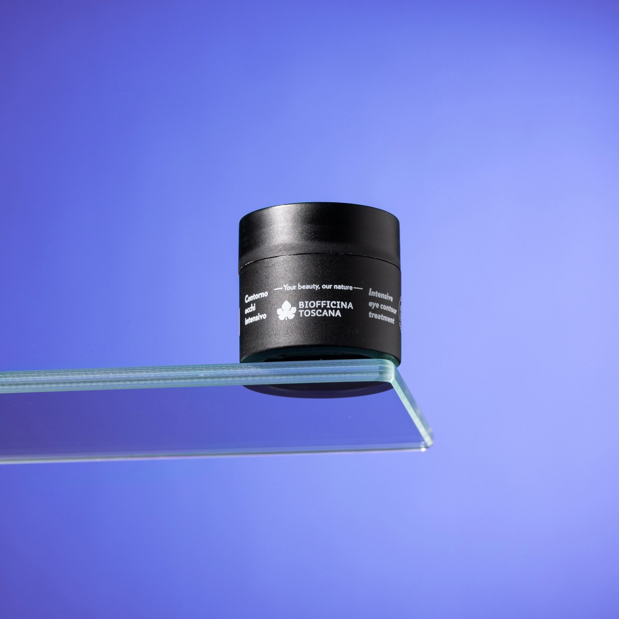 Vaso nero su una lastra di vetro. Sul vaso, "Contorno occhi intensivo".