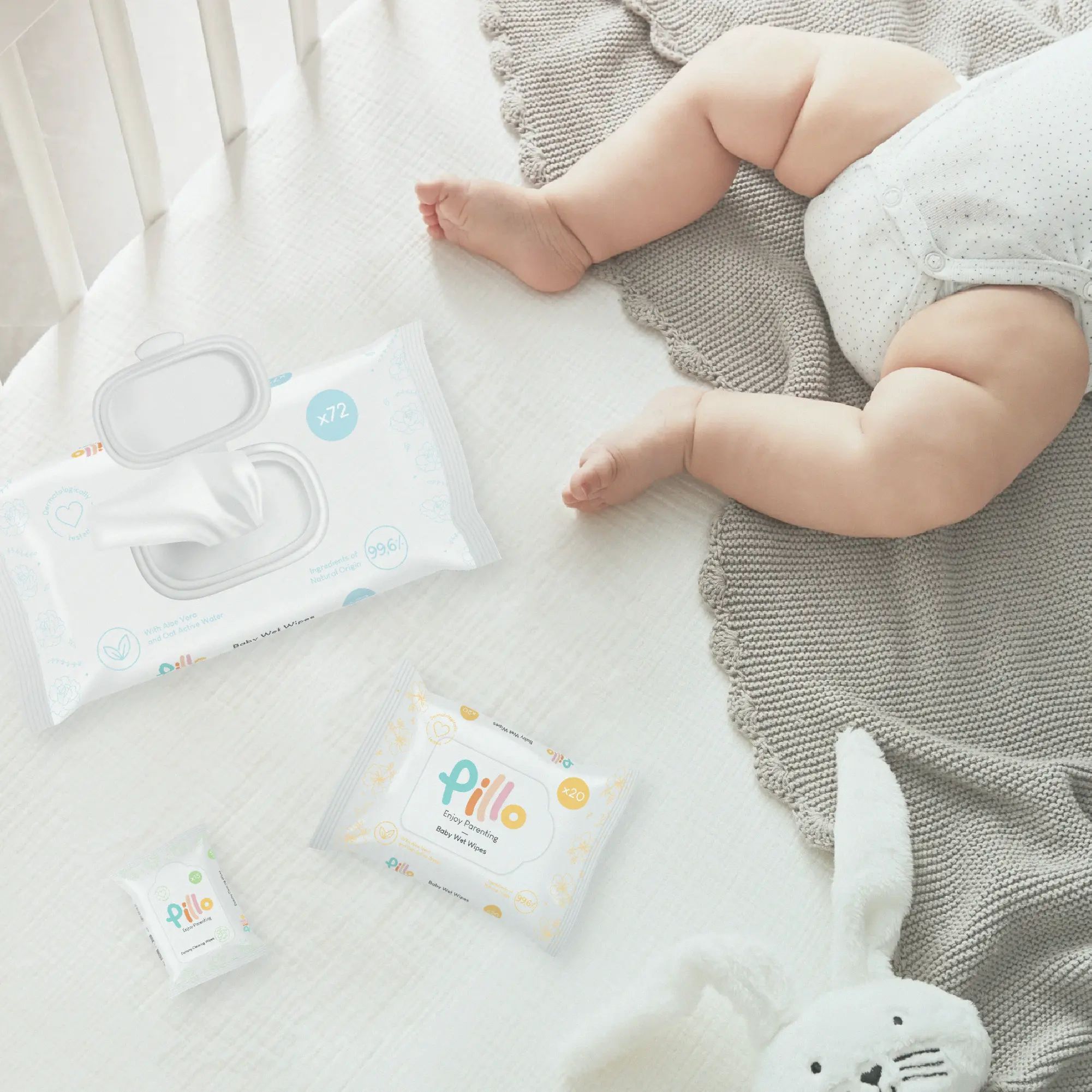 Confezioni di salviette Pillo Baby. Una aperta. Un bambino è sdraiato accanto.