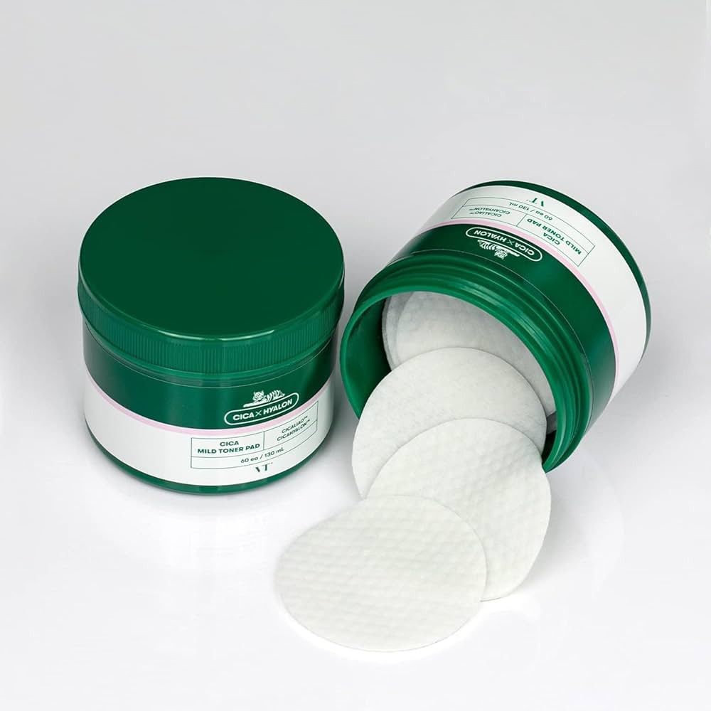 Barattolo verde e coperchio aperti. Tamponi tonici bianchi accanto. Scritta: CICA x HYALON, CICA Mild Toner Pad. Marchio: VT.