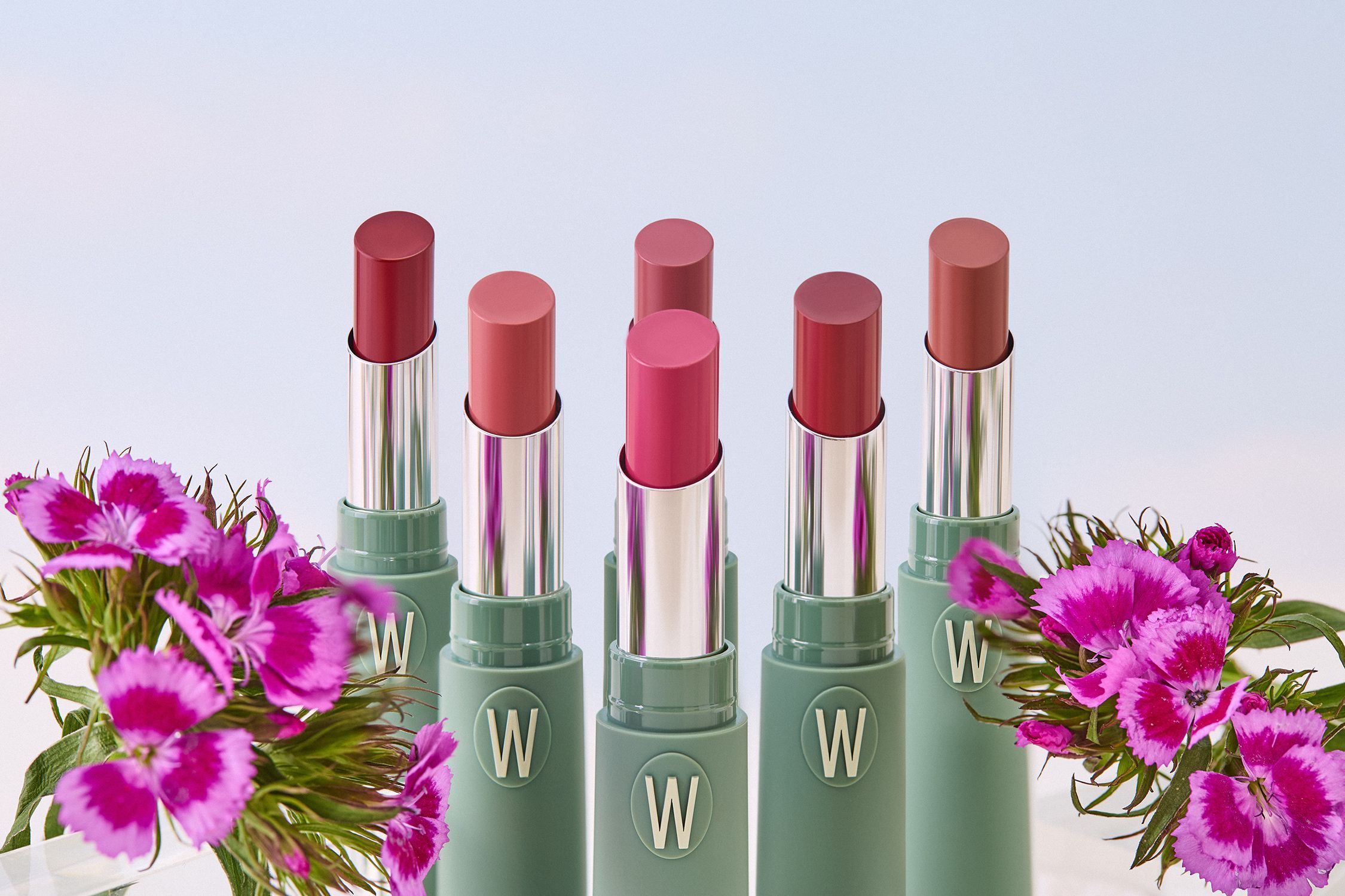 Diversi rossetti verdi con rossetti aperti. Fiori in primo piano.