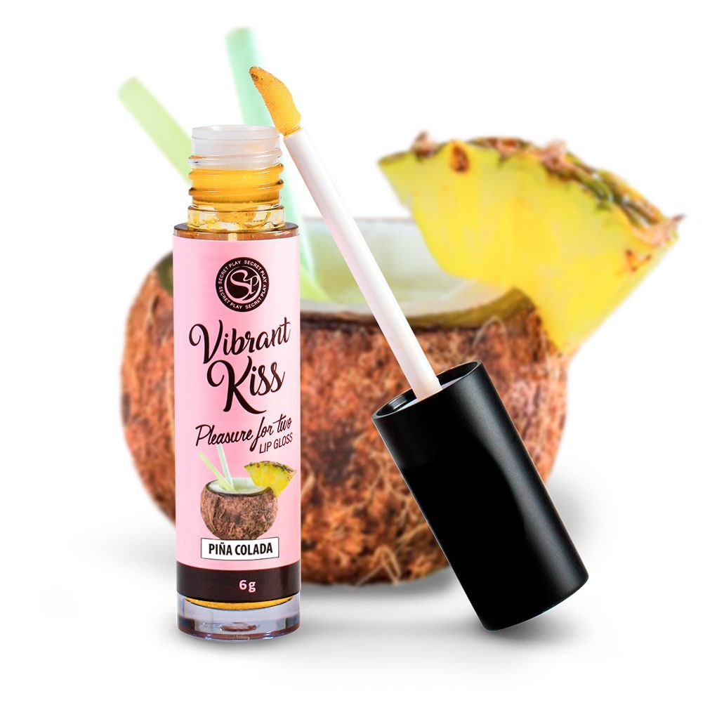 Flacone di lucidalabbra con applicatore, accanto a un cocktail con ananas e cannucce. Scritta: Vibrant Kiss, Pina Colada.