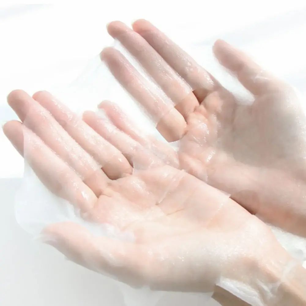 Due mani che tengono una maschera per il viso umida. La maschera è trasparente e copre i palmi.