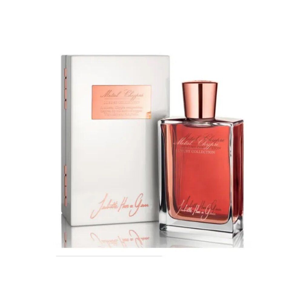 Flacone di profumo e confezione. Flacone rettangolare con tappo color rame. Confezione bianca con testo.