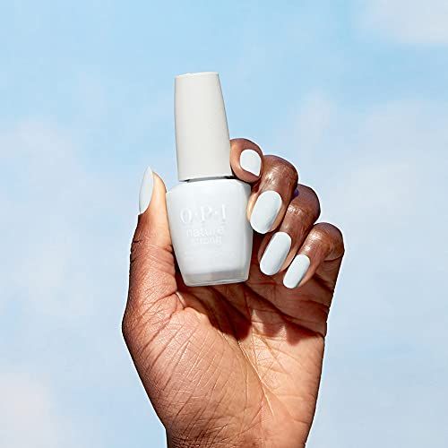 Mano che tiene un flacone di smalto azzurro. OPI Nature Strong. Cielo blu sullo sfondo.