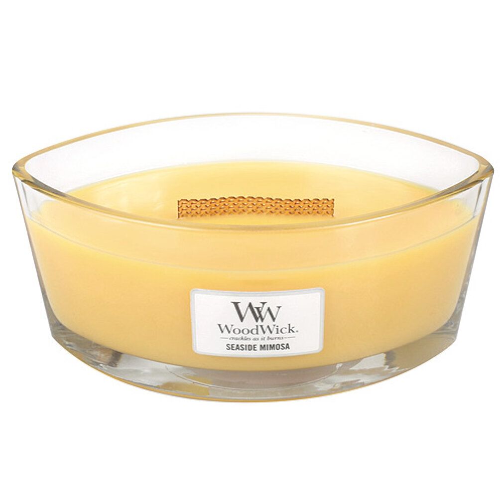 Candela Ellipse con cera gialla in contenitore di vetro. Stoppino in legno. Etichetta "WoodWick Seaside Mimosa".