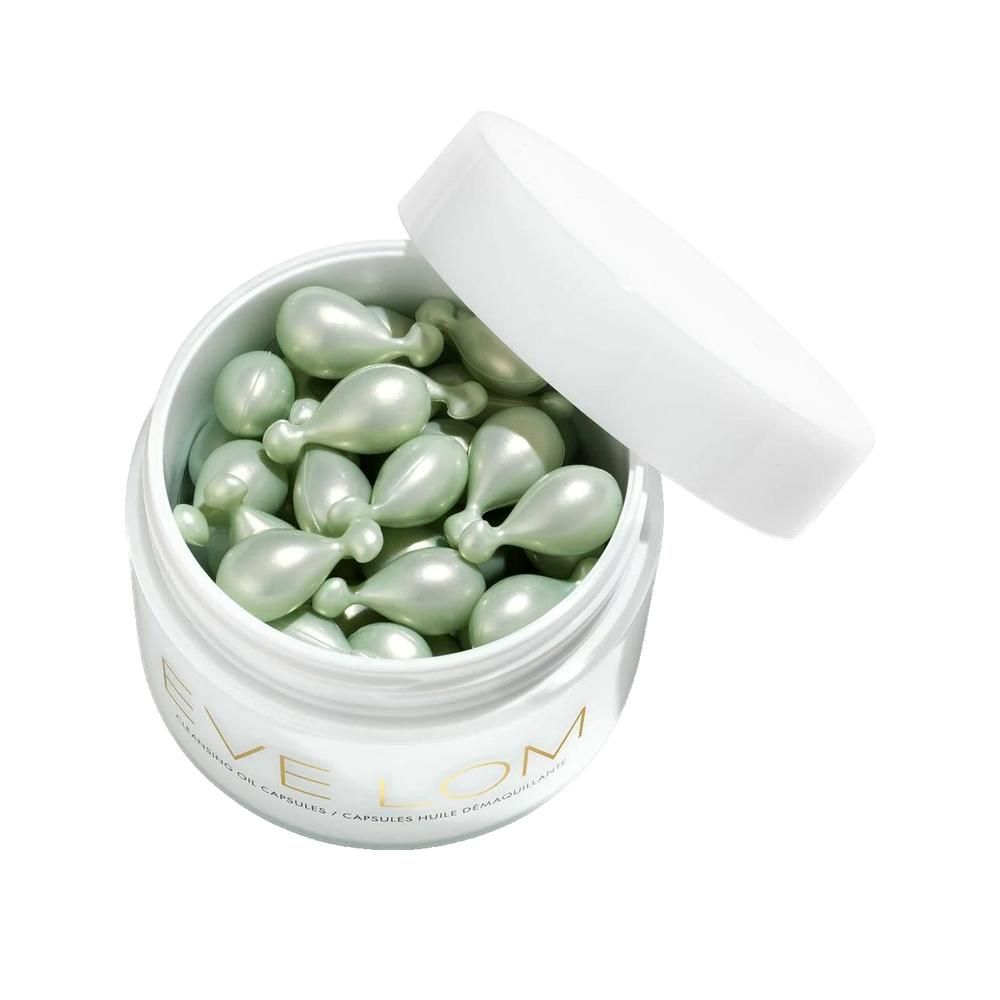 Barattolo bianco aperto con capsule verdi a forma di goccia. Coperchio accanto.