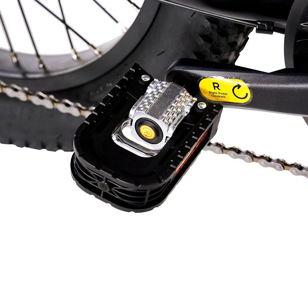 Primo piano di un pedale di una bicicletta elettrica nera. Visibile: pedale, catarifrangente, adesivo giallo.