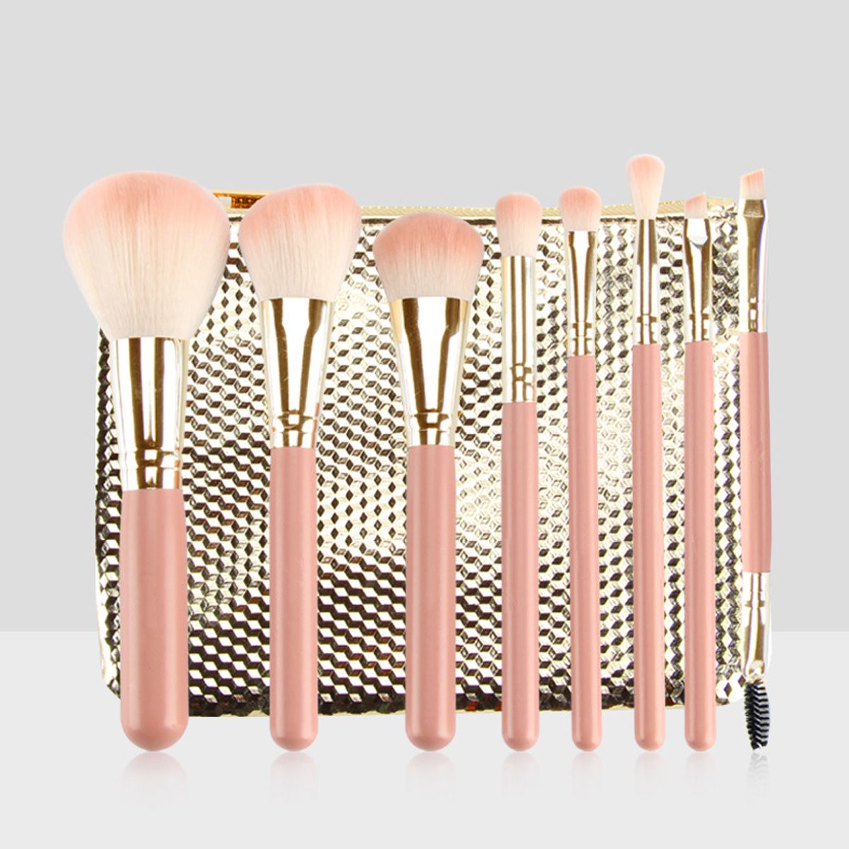 Set di otto pennelli per il trucco rosa con dettagli dorati e una pochette dorata.