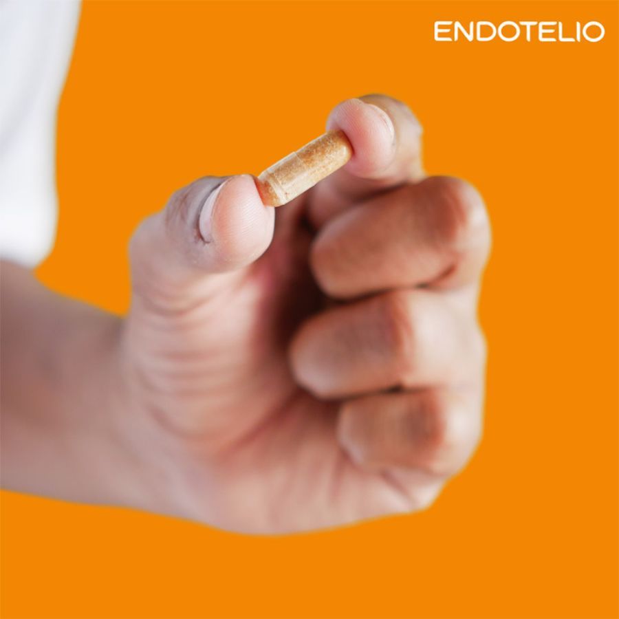 Mano che tiene una singola capsula. Scritta: Endotelio. Sfondo arancione.