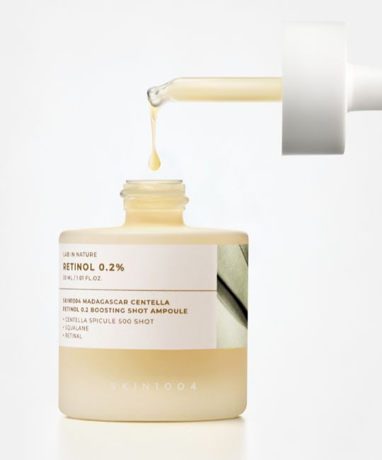 Flacone di vetro con pipetta. Scritta: Retinolo 0,2%. Nome prodotto: SKIN1004 Madagascar Centella Retinol 0.2 Boosting Shot Ampoule. Gocce.
