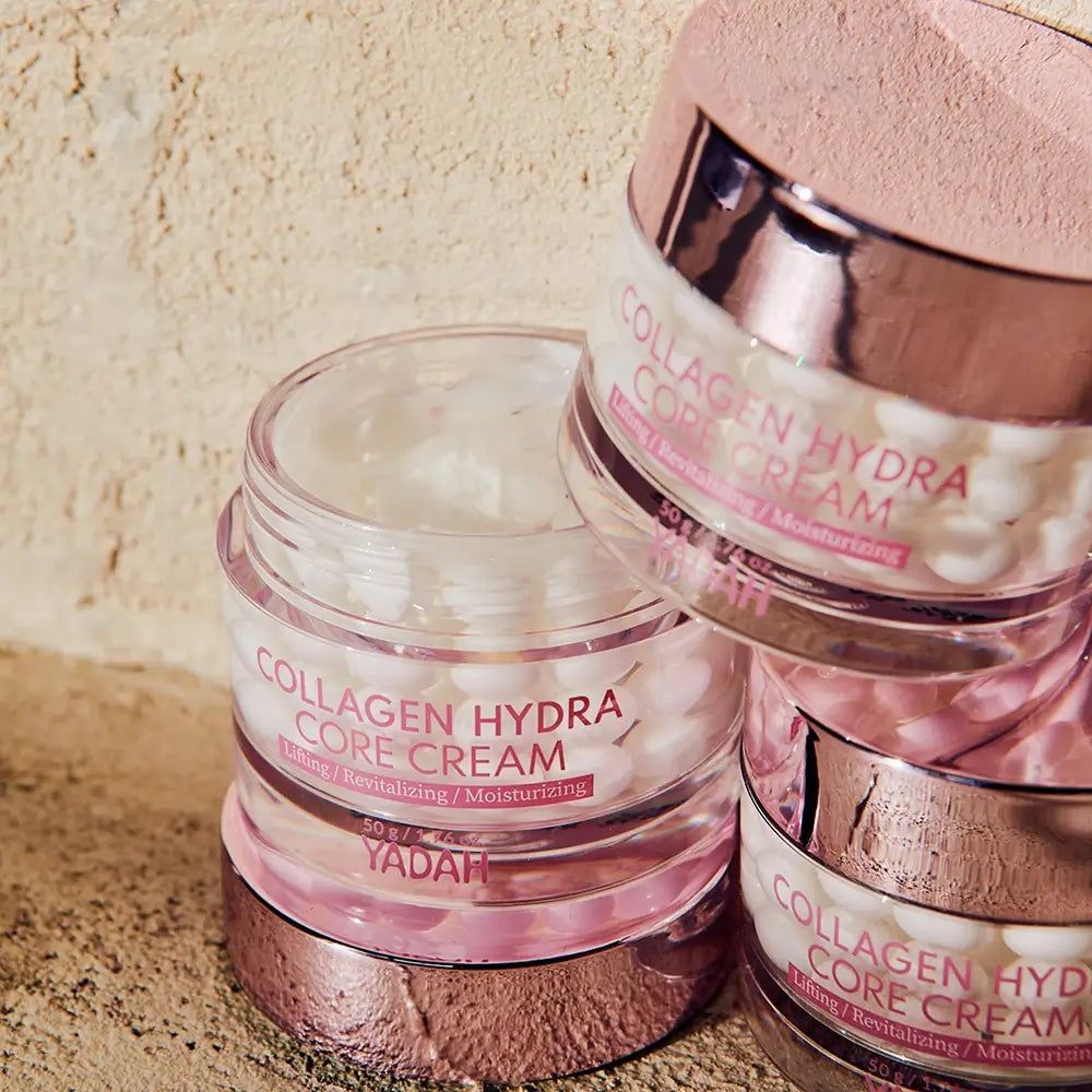 Tre vasetti di crema impilati. Scritta: Collagen Hydra Core Creme. Testo: Lifting / Revitalizing / Moisturizing. Marchio: YADAH.