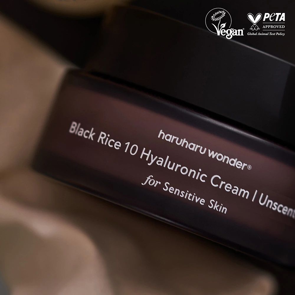 Vasetto marrone scuro con coperchio nero. Scritta: Black Rice 10 Hyaluronic Cream Unscented. Sigilli Vegan e PETA.