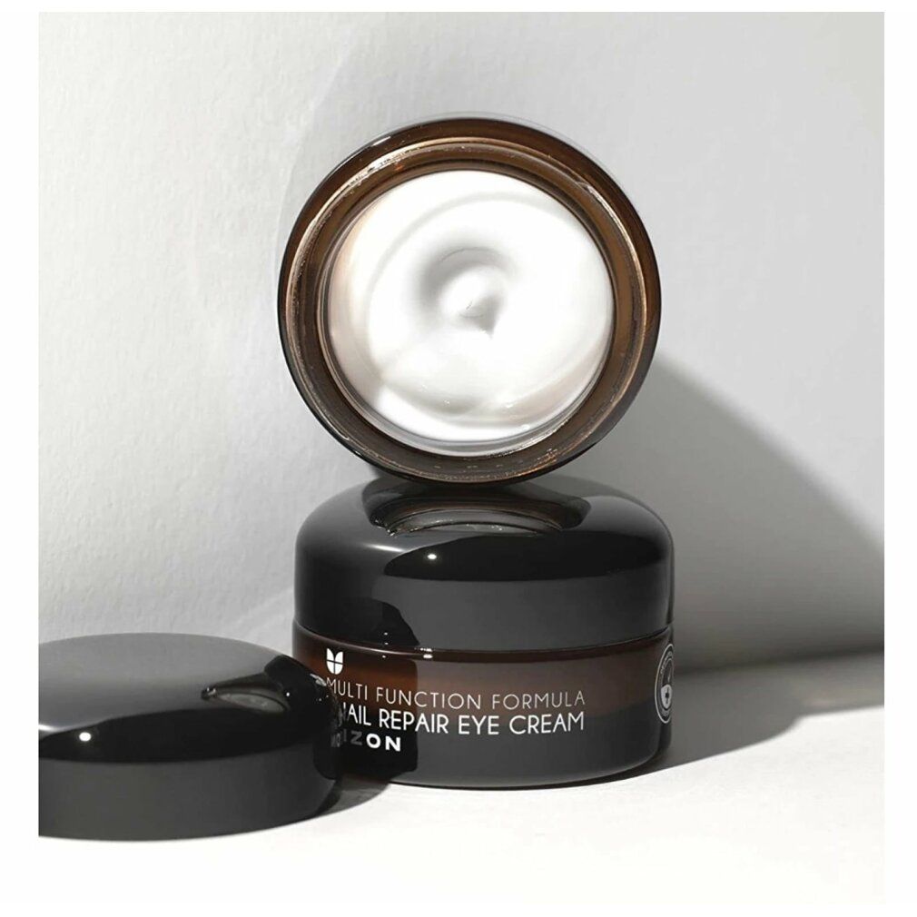Vasetto di vetro marrone aperto con coperchio nero. Crema visibile. Scritta: Multi Function Formula Snail Repair Eye Cream MIZON.