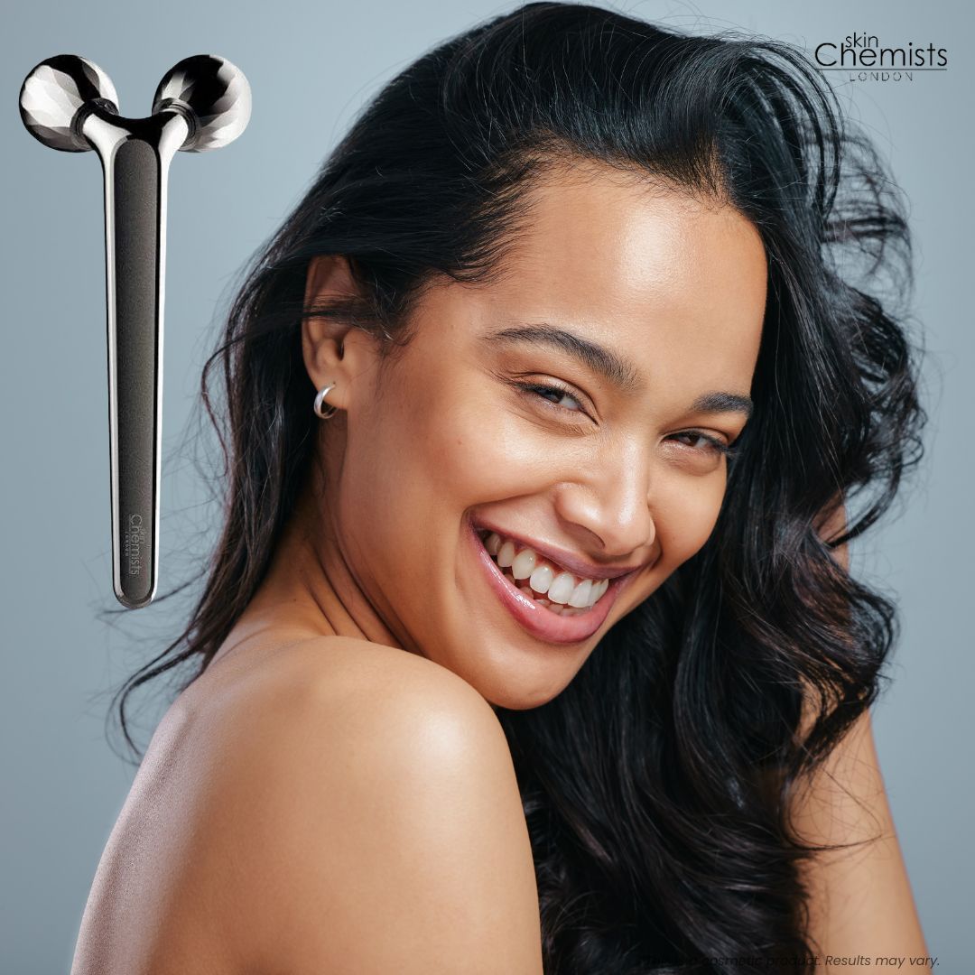 Rullo massaggiatore viso accanto a donna sorridente. Design in metallo lucido.