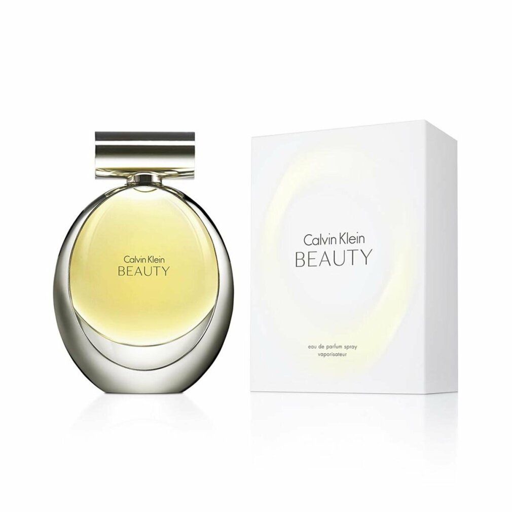 Flacone di profumo e confezione. Flacone rotondo, tappo argentato, liquido giallognolo. Confezione bianca, scritta Calvin Klein BEAUTY.