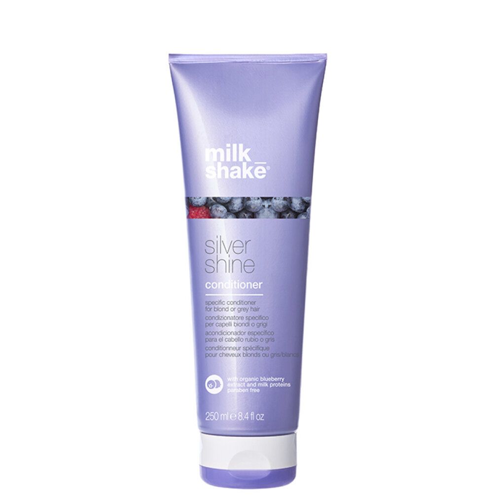 Tubo lilla con prodotto. Scritta: milk_shake Silver Shine Conditioner. Illustrazione di mirtilli.