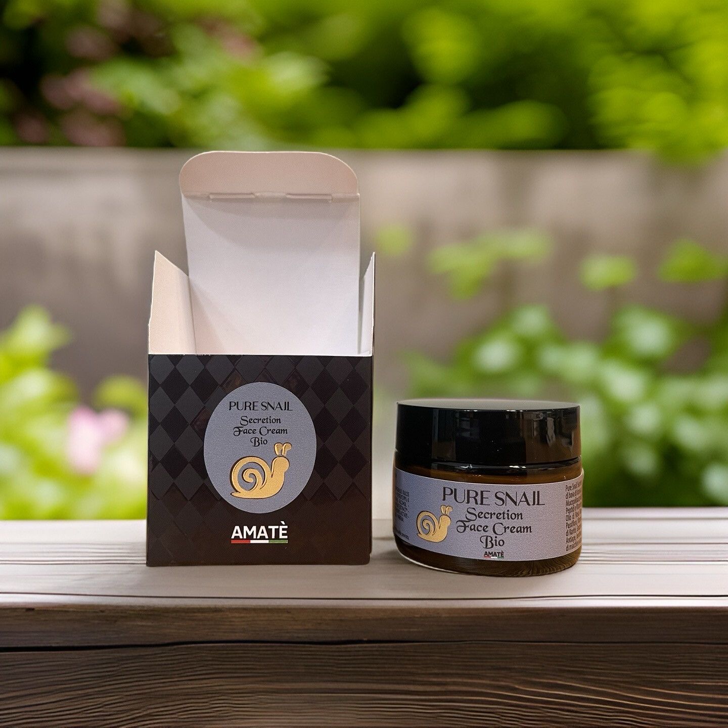 Scatola aperta e vasetto di crema. Scritta: Pure Snail Secretion Face Cream Bio. Logo: lumaca dorata. Sfondo: verde.