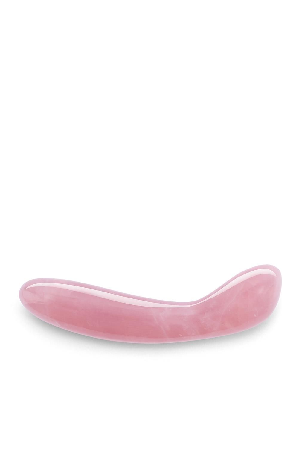 Bacchetta curva rosa in quarzo rosa. Superficie liscia, forma arrotondata. Prodotto benessere.