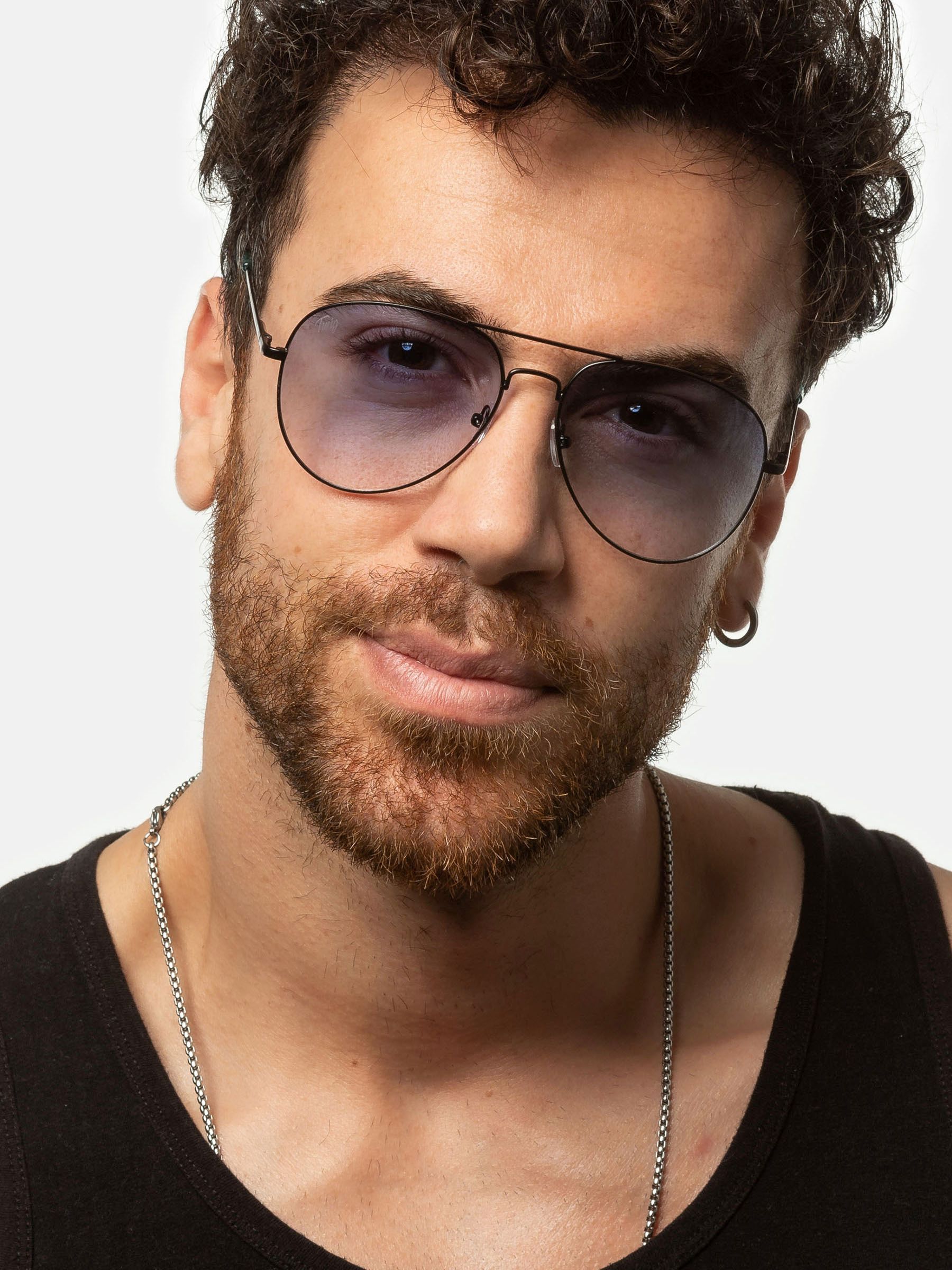 Uomo con occhiali da sole. Montatura nera, lenti blu. Primo piano.