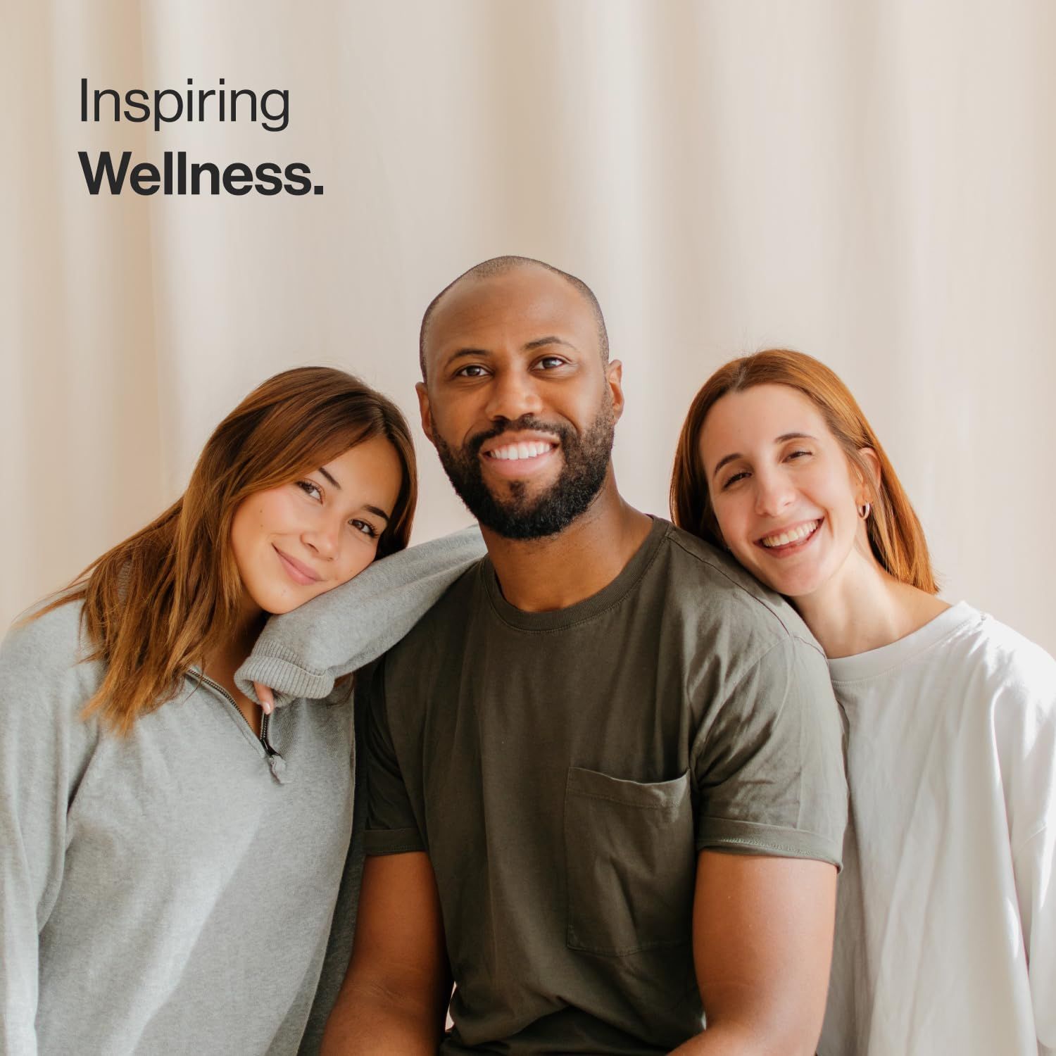 Tre persone sorridono alla fotocamera. Testo: Inspiring Wellness.