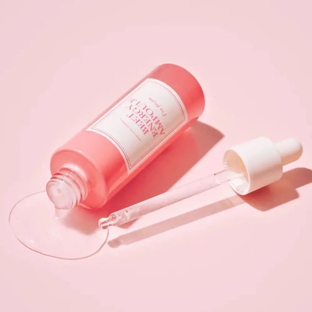Flacone rosa con pipetta sdraiato. Liquido che fuoriesce. Testo: BEET ENERGY AMPOULE, I'm from.