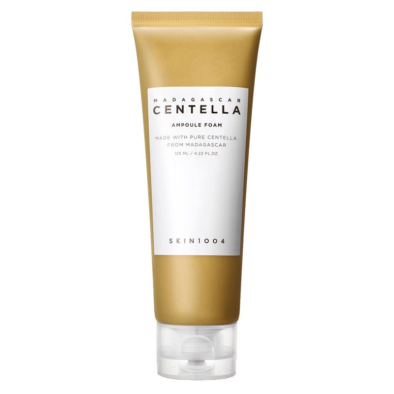 Tubo beige con etichetta bianca. Scritta: MADAGASCAR CENTELLA, Ampoule Foam, SKIN1004. Chiusura trasparente.