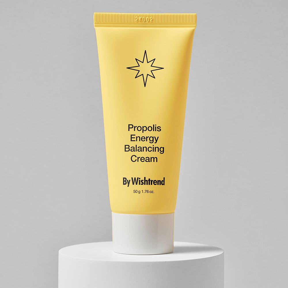 Tubo giallo su piedistallo. Testo: Propolis Energy Balancing Cream, By Wishtrend. 50g 1.76 oz. Simbolo stella.