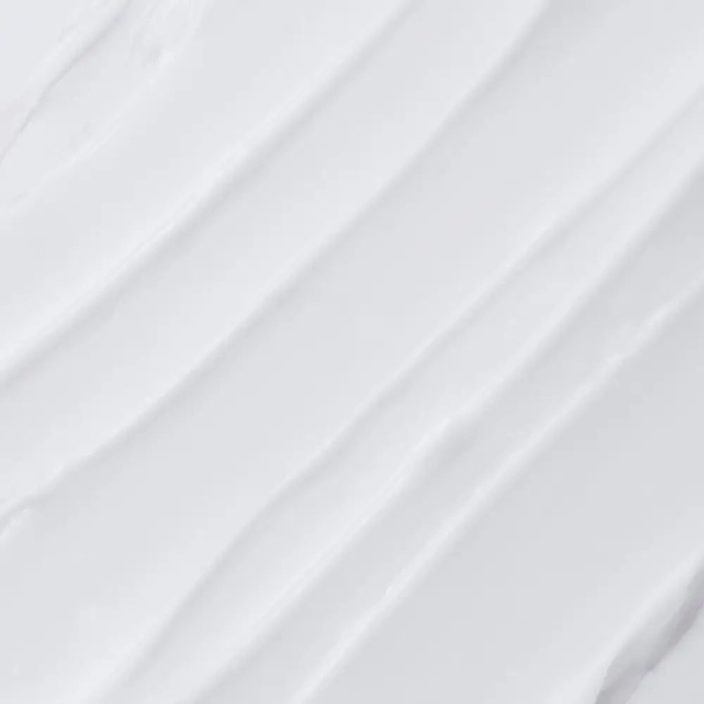 Primo piano di crema bianca. Texture della crema con strisce diagonali.
