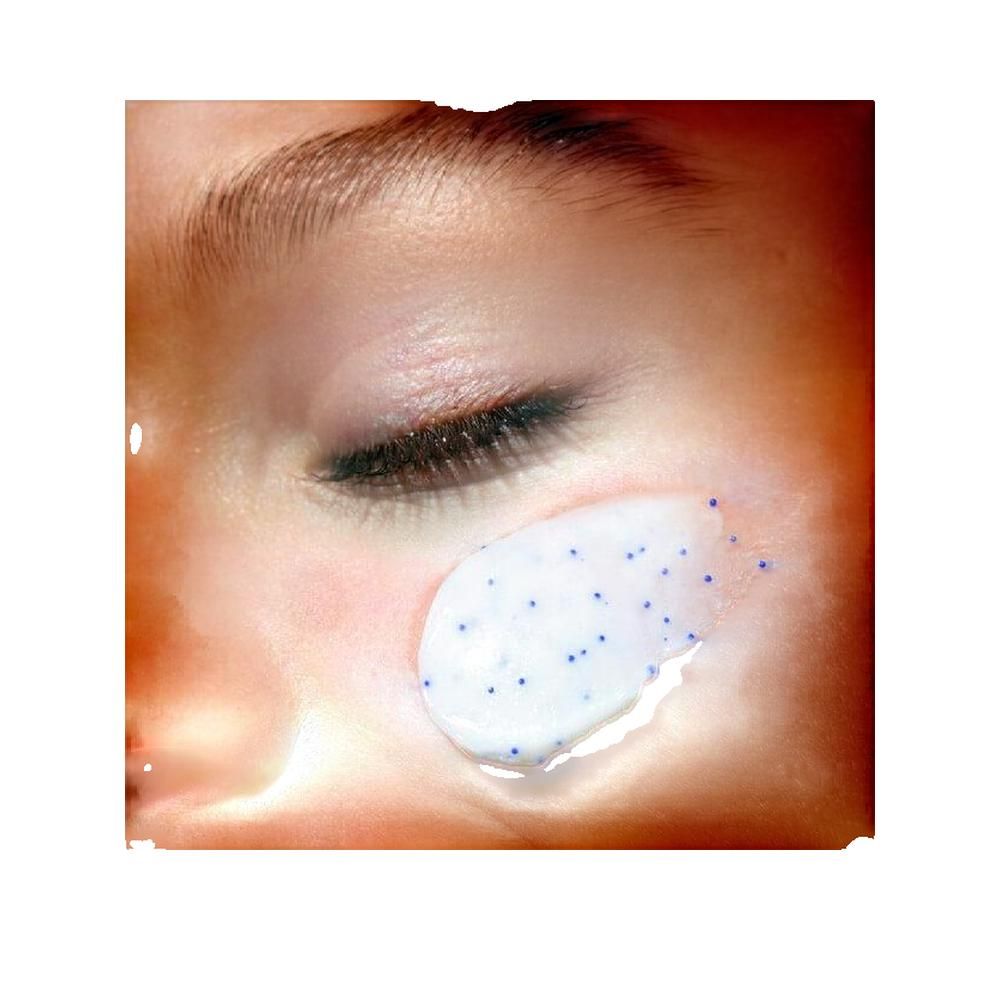 Primo piano di un occhio con crema applicata. Crema con particelle blu sulla pelle.