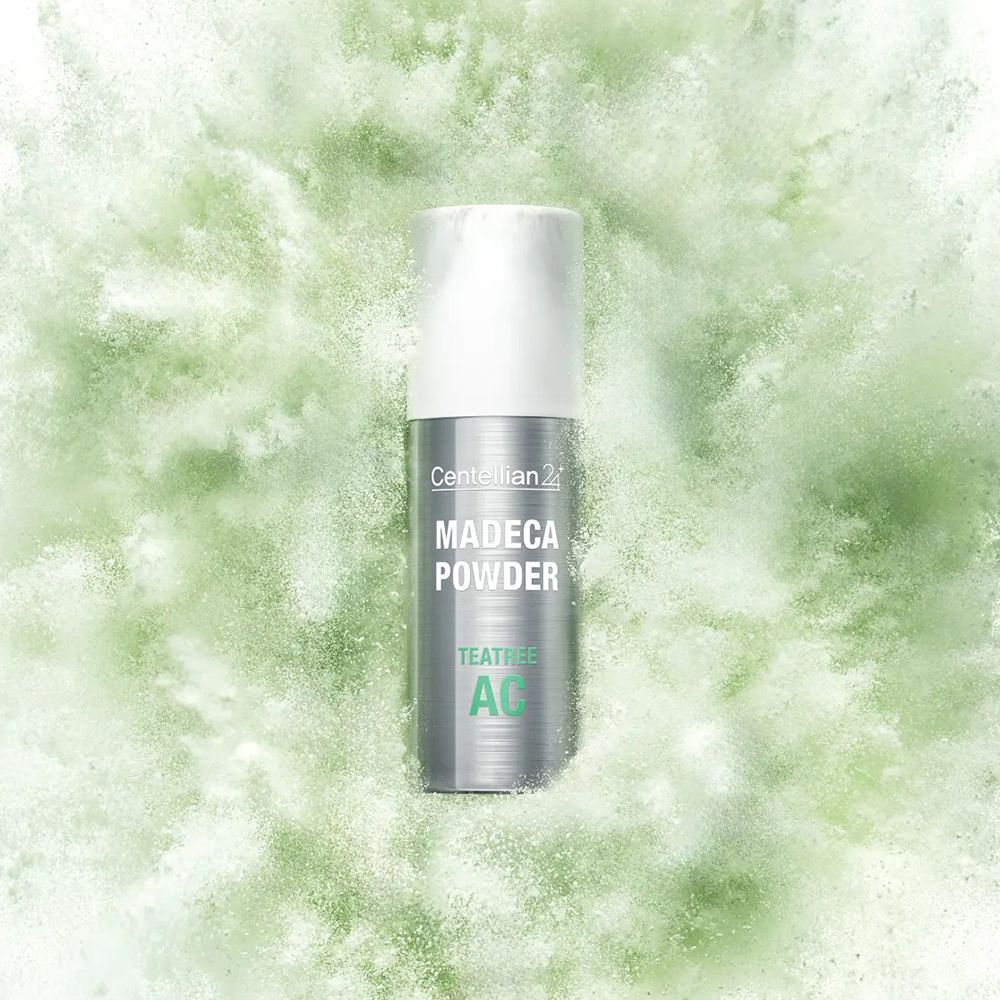 Flacone Centellian24 Madeca Powder TeaTree AC in una nuvola di polvere verde.