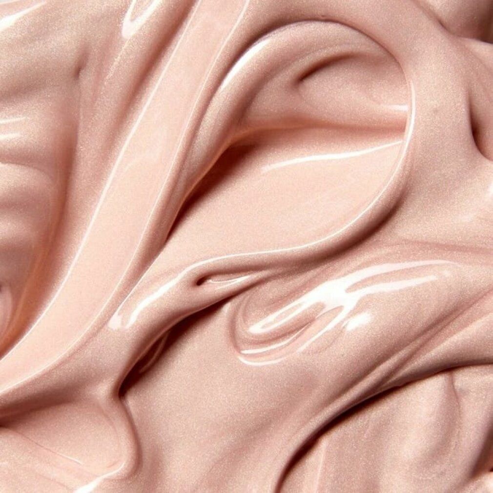 Primo piano di crema rosa. Texture lucida con forme ondulate. Nessun imballaggio o etichettatura visibile.