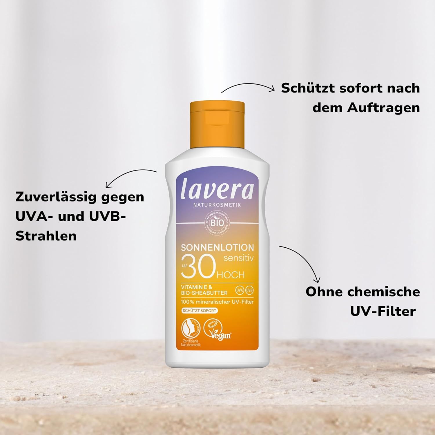 Flacone di lozione solare, in piedi. Testo: lavera, Sonnenlotion Sensitiv LSF 30, BIO, Vegan. Frecce puntano al testo.