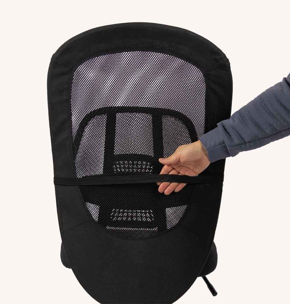 Supporto per la schiena con rete nera. Mano che raggiunge una cinghia di fissaggio. Sfondo bianco.