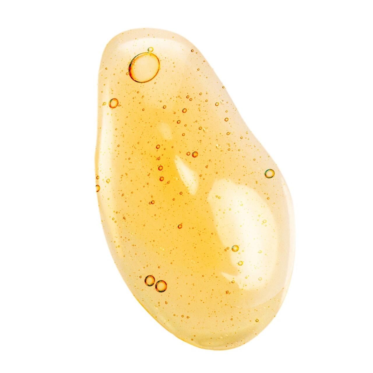 Goccia di liquido giallo a forma di goccia con piccole bolle. Nessuna scritta visibile.