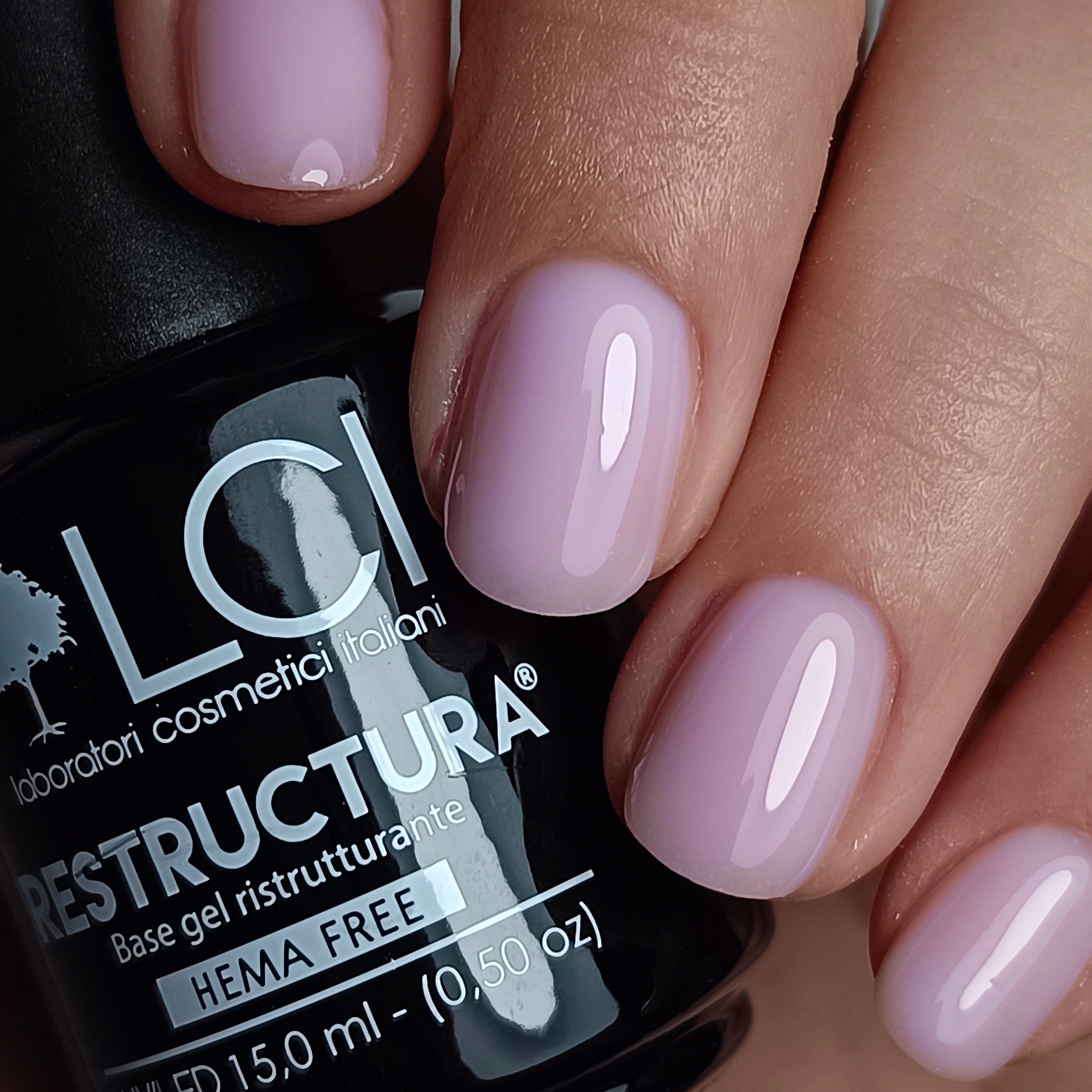 Mani con unghie smaltate. Flacone Restructura Base&Go. Scritta: HEMA FREE.