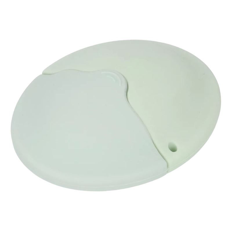 Applicatore verde chiaro con coperchio. Il coperchio è diviso in due parti e ha una piccola apertura. Il prodotto è in silicone.