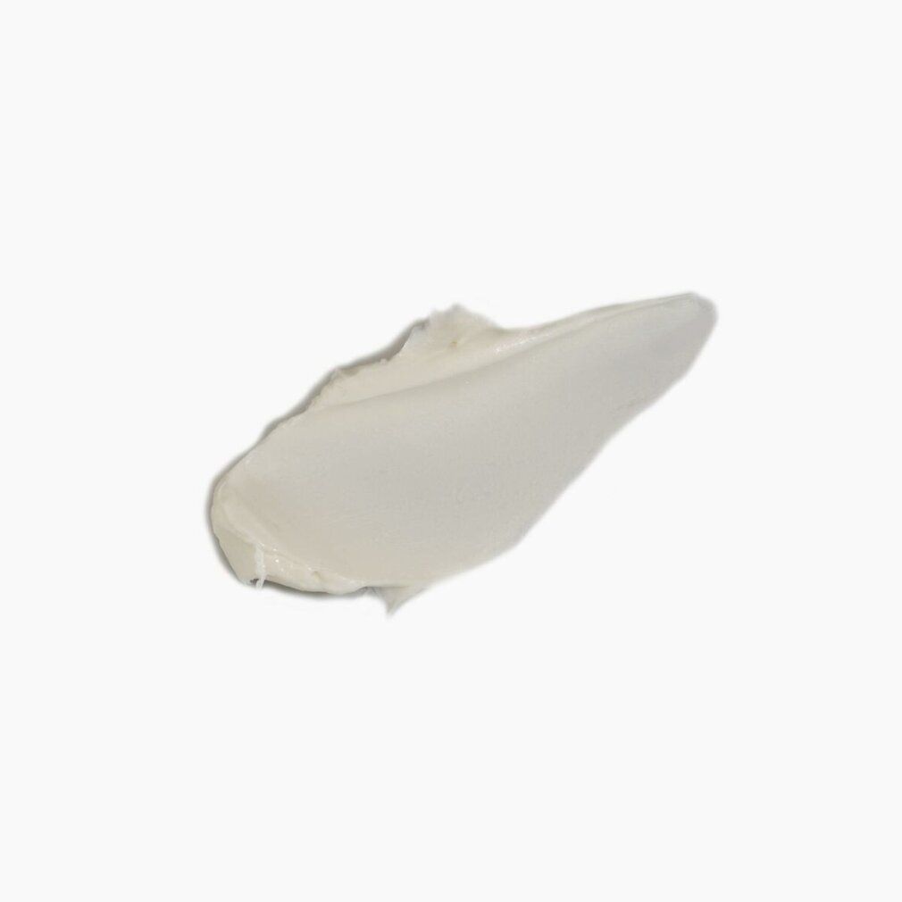 Una macchia di crema bianca su sfondo bianco. La forma è allungata e irregolare.