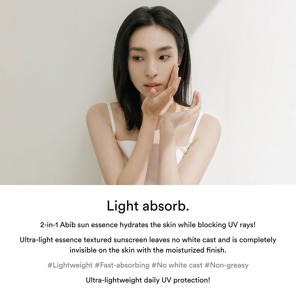Donna che si tocca il viso. Testo: Light absorb. L'essenza solare Abib idrata la pelle.