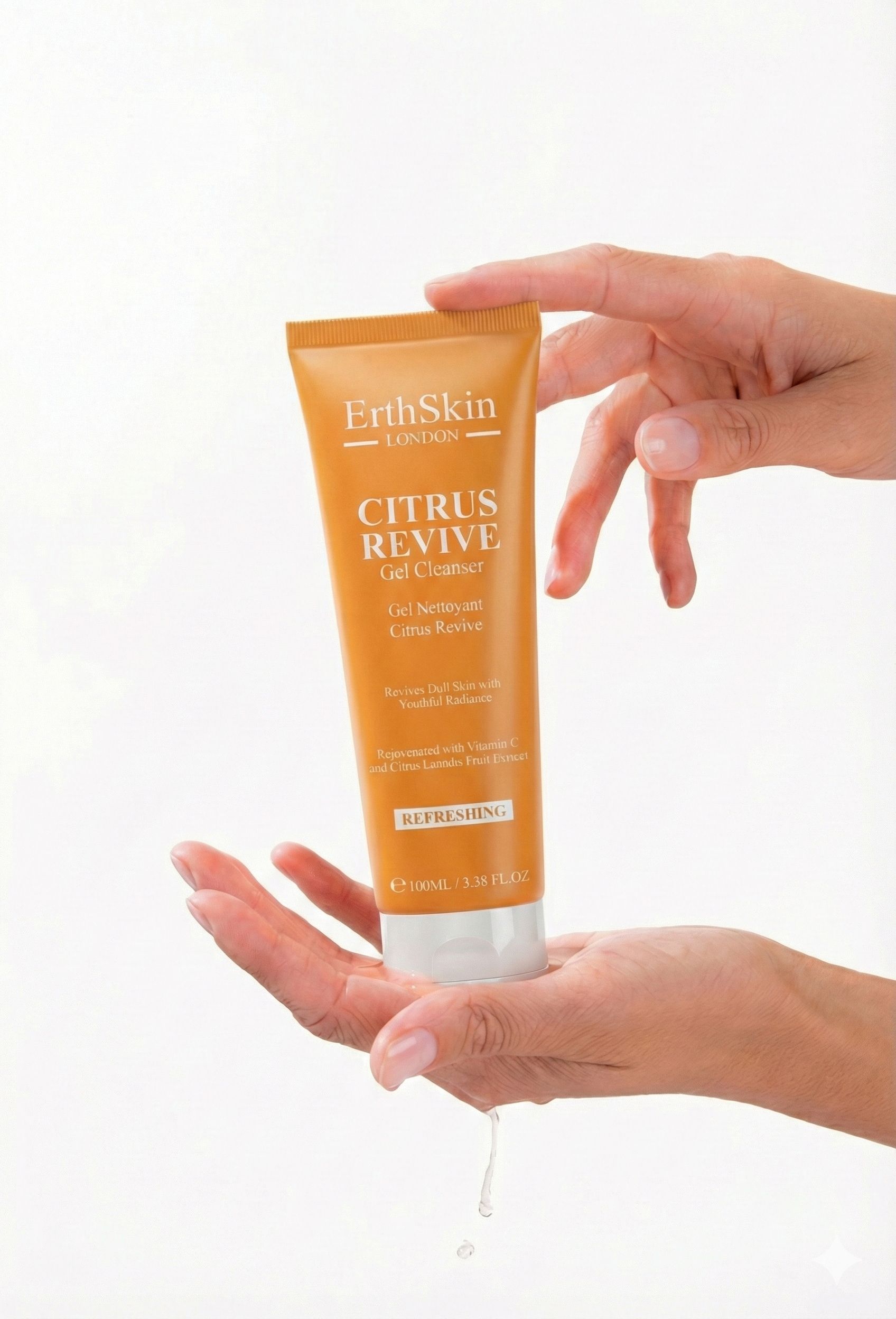 Mani che tengono un tubo arancione. Scritta: ErthSkin London CITRUS REVIVE Gel Cleanser. Goccia di liquido.