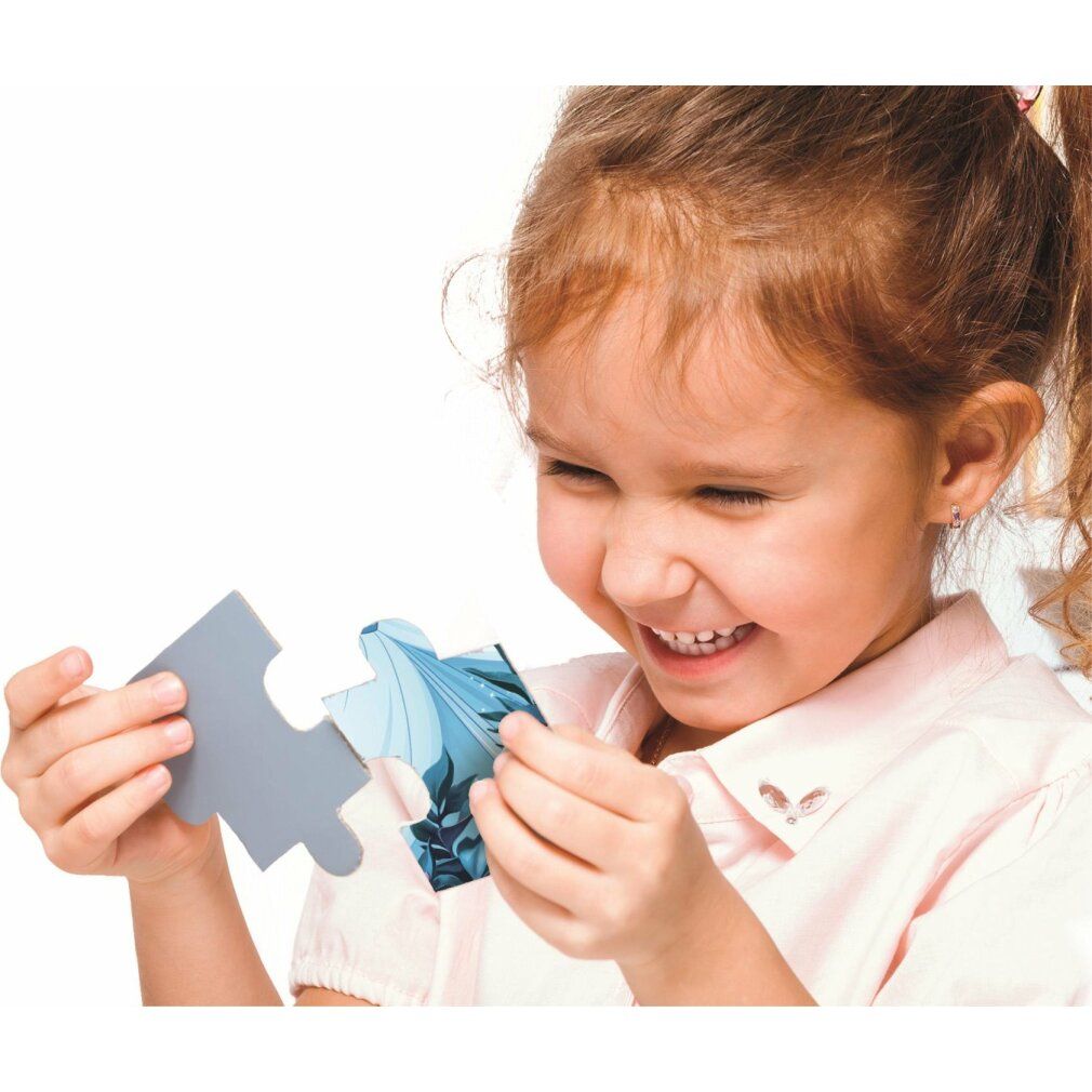 Bambino tiene un pezzo di puzzle. Pezzo di puzzle con motivo blu. Bambino sorridente. Sfondo: bianco.