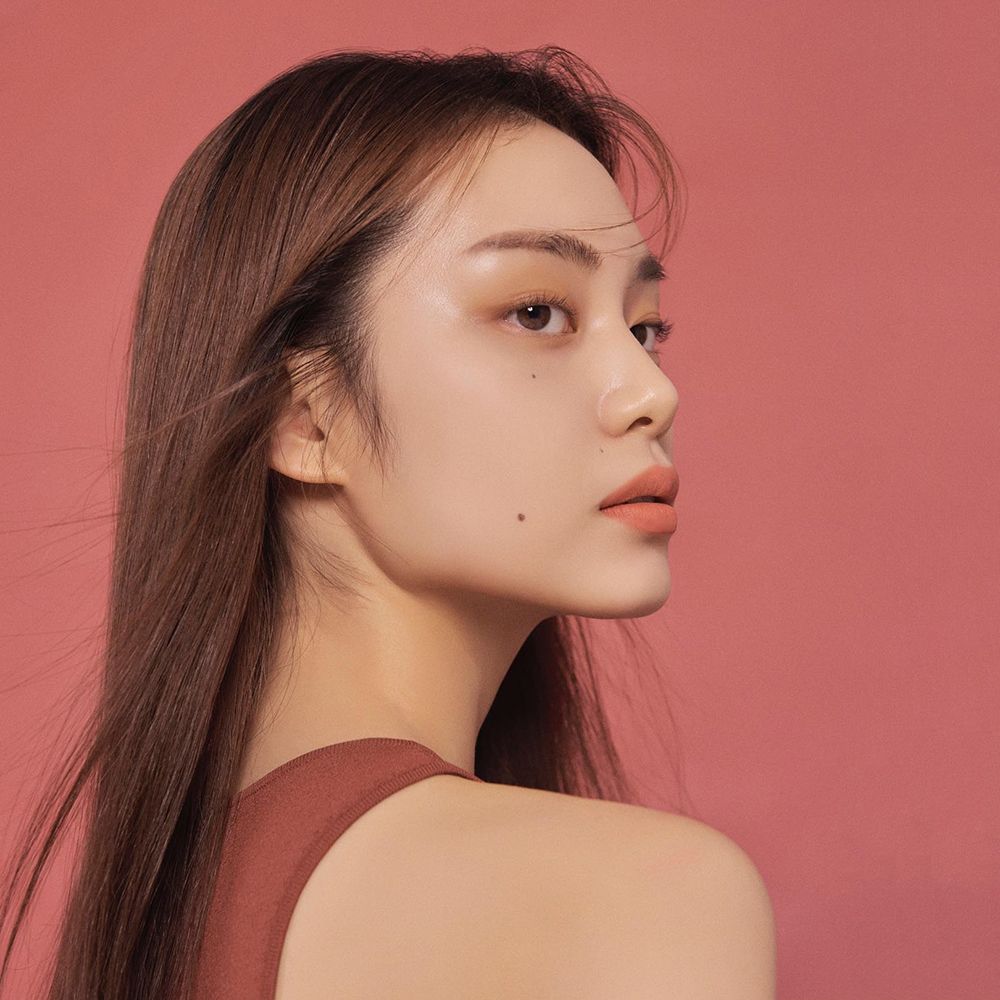 Ritratto di donna con trucco labbra. Sfondo rosa. Nome del prodotto non visibile.