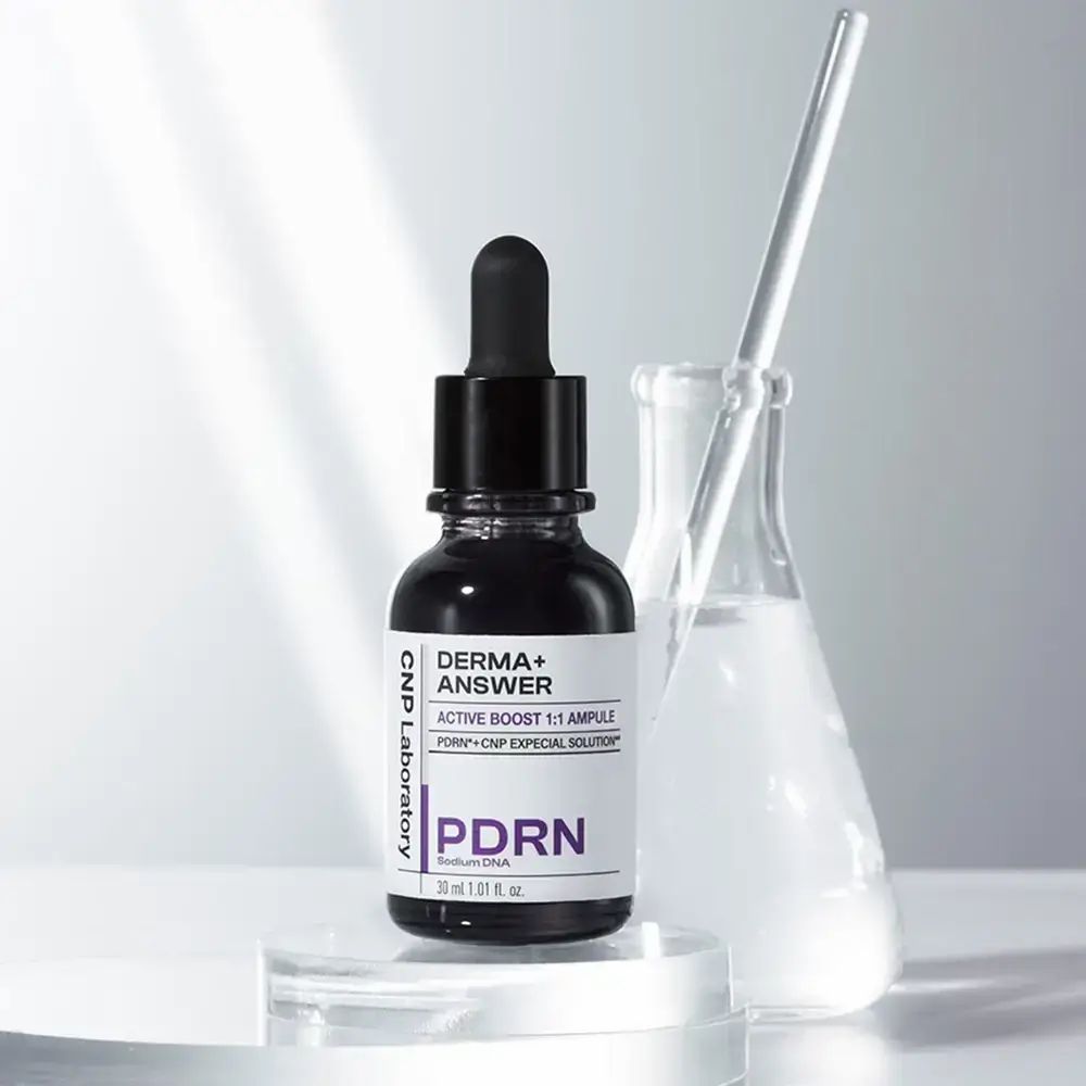 Flacone di vetro scuro con pipetta. Etichetta: DERMA+ ANSWER, PDRN, CNP Laboratory. Contenitore di vetro sullo sfondo.