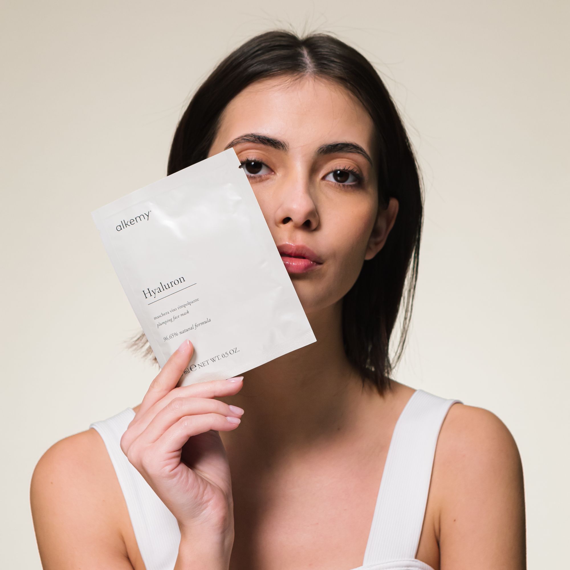Donna tiene in mano una confezione bianca di maschera viso Alkemy Hyaluron.