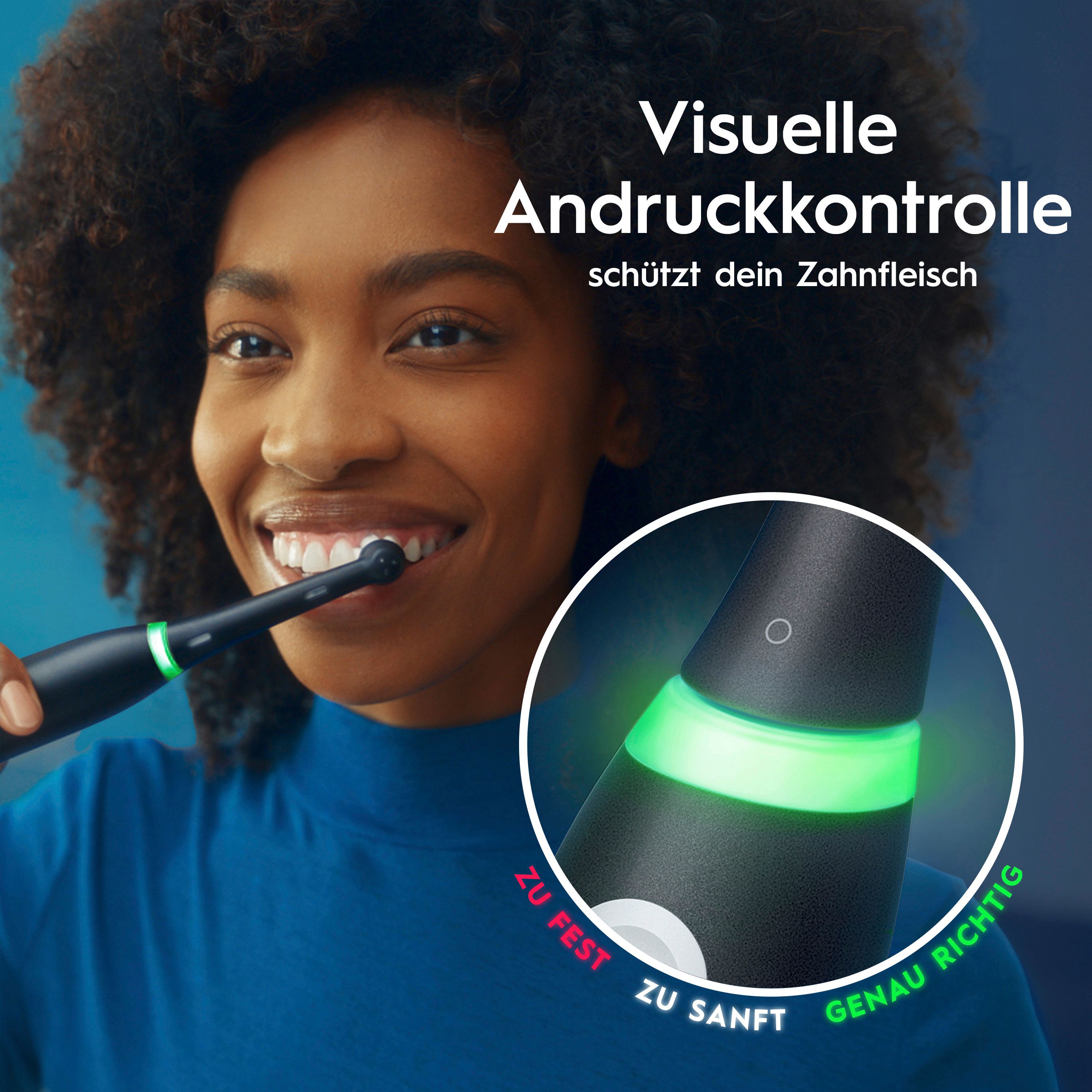 Donna che si lava i denti con spazzolino elettrico nero. Controllo visivo della pressione: verde per la pressione corretta, rosso per troppo forte.
