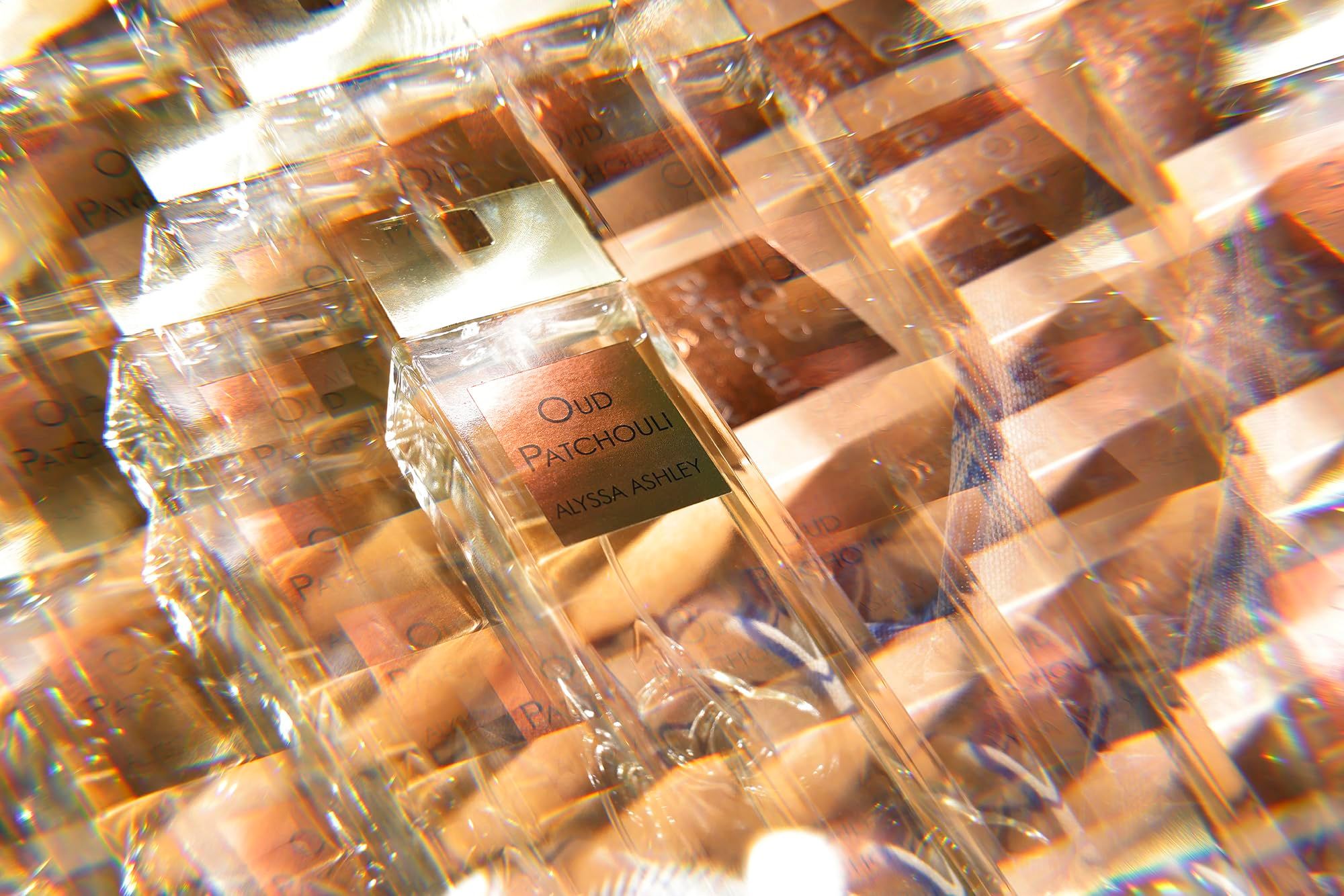 Flaconi Alyssa Ashley Oud Patchouli confezionati. Scritta Oud Patchouli, Alyssa Ashley. Diversi flaconi confezionati in pellicola.