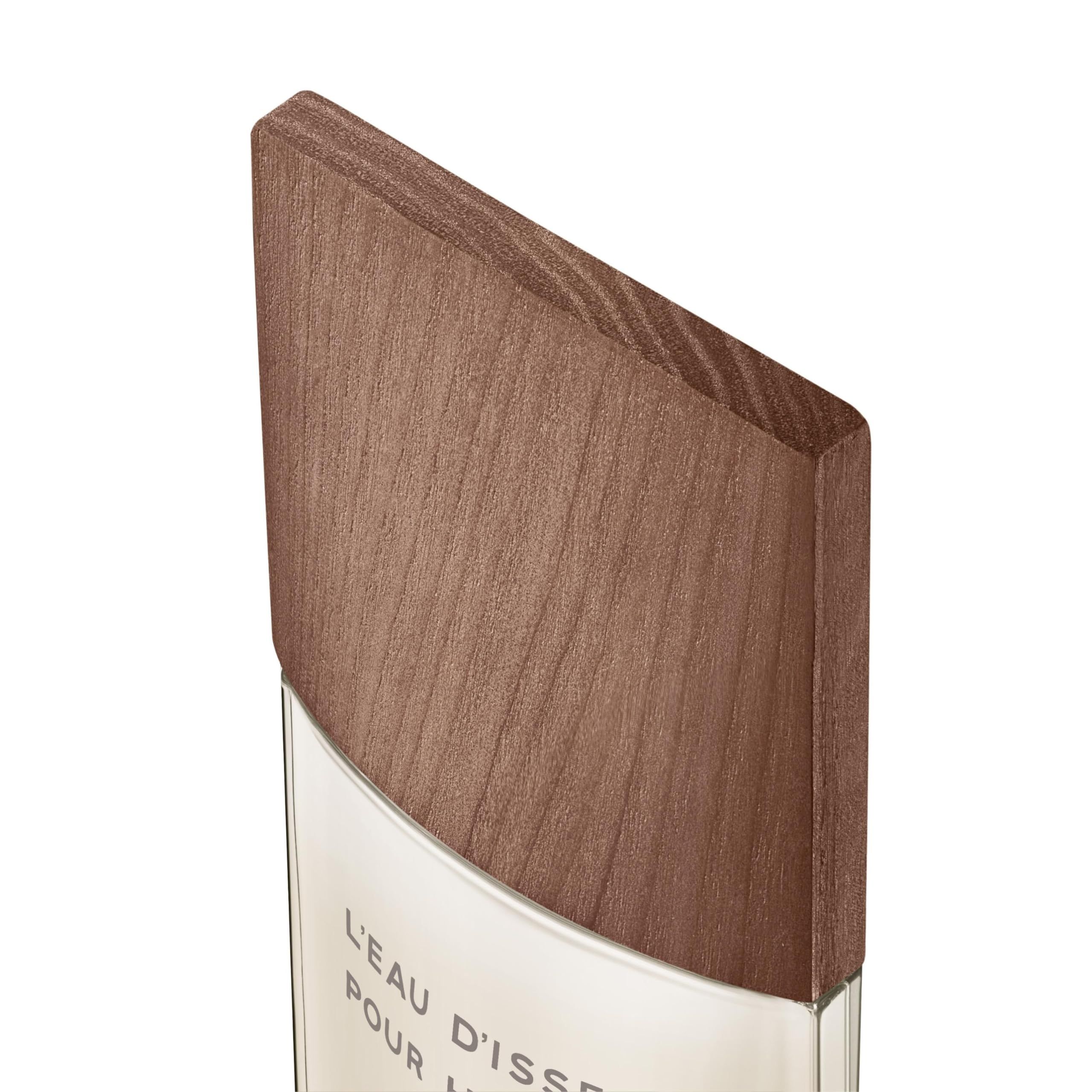 Primo piano del tappo in legno di un flacone di profumo. Testo: L'Eau d'Issey Pour Homme.