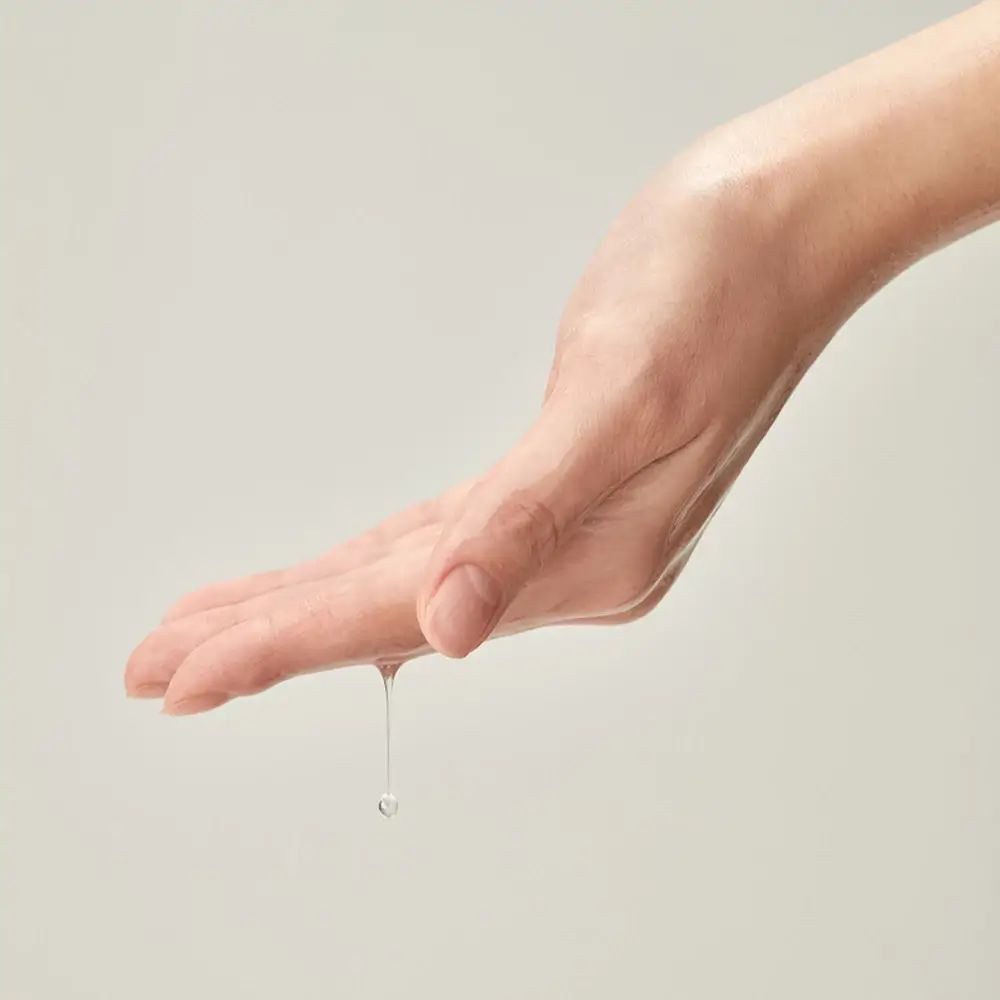 Mano con gocce di liquido. Il liquido gocciola dal palmo.